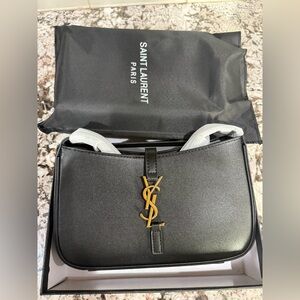 New Saint Laurent Le shoulder bag. Black leather with gold clasp